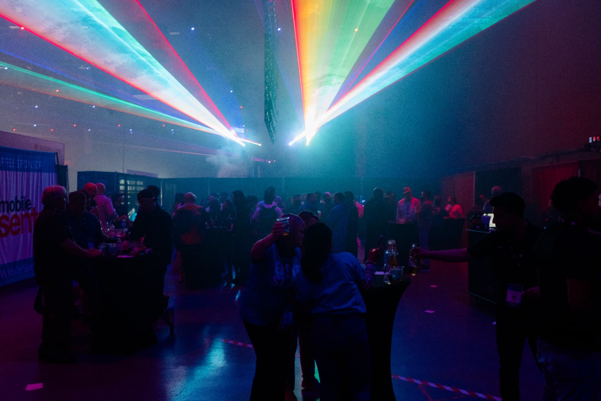Attendees under a laser light show at the GRE after-hours party