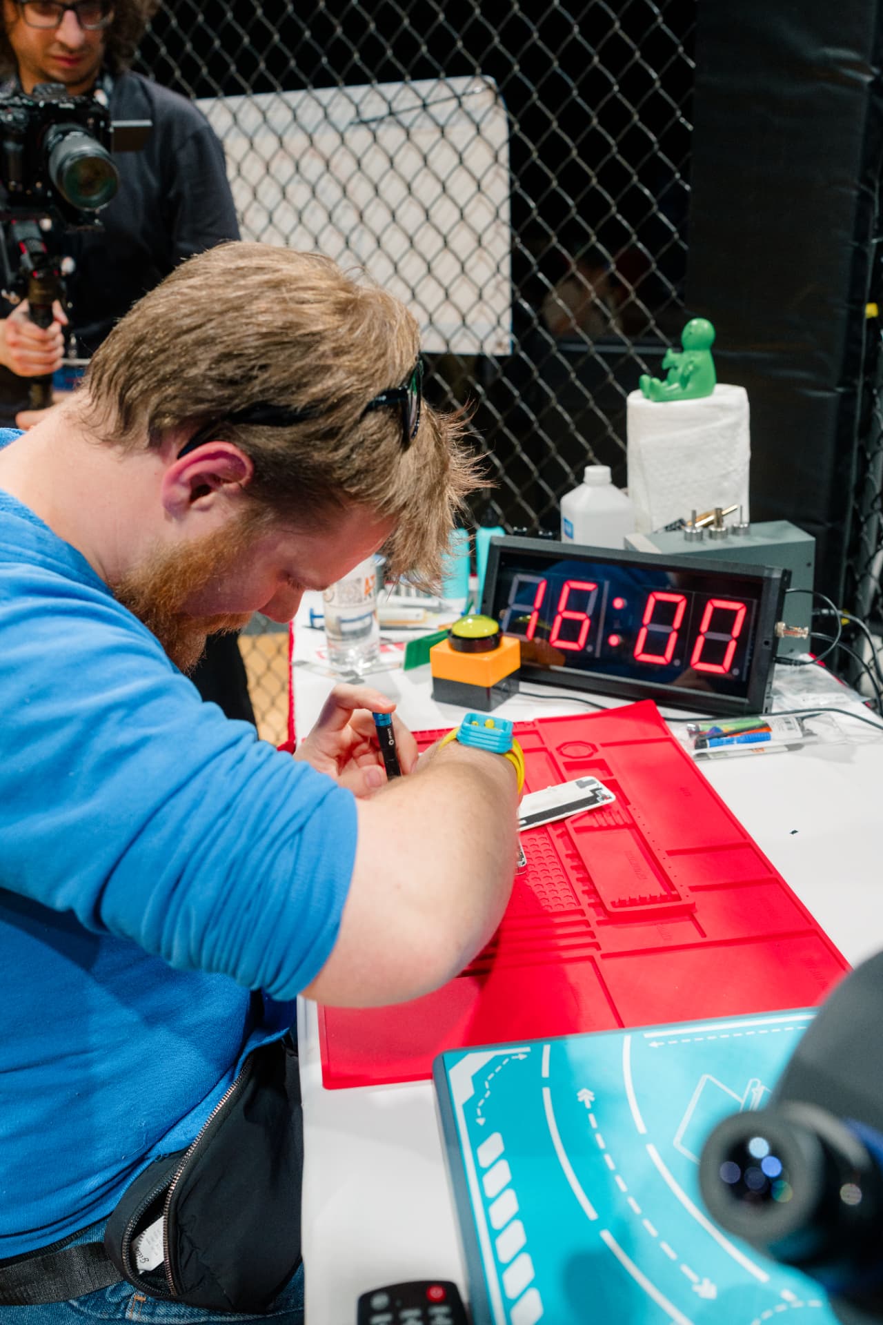 Competitor swapping a phone screen against the clock inside the octagon
