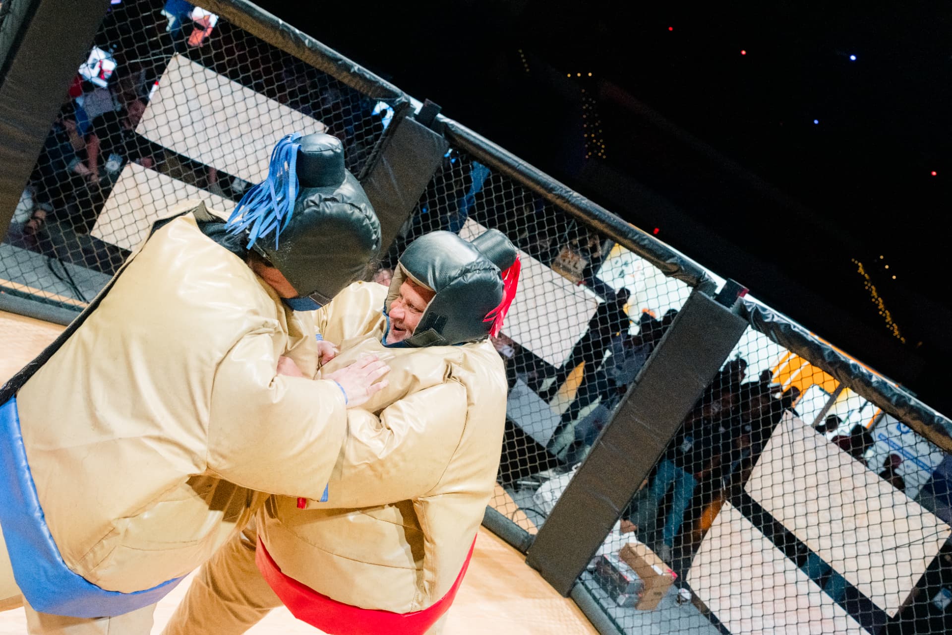 Two competitors in padded sumo suits wrestling inside The Octagon at GRE