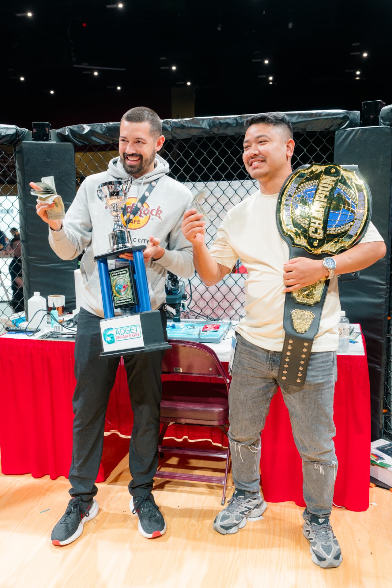 GRE Repair Championship winners with trophy and title belt inside the octagon